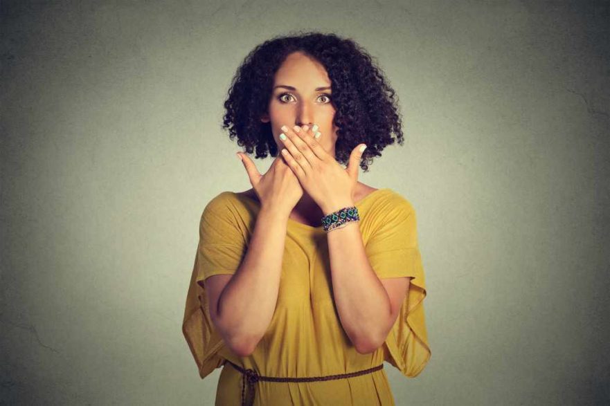 Woman covering mouth - speak no evil