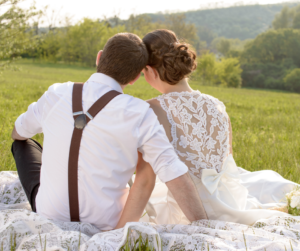 Keep love alive: Couple in wedding clothes sitting on a hillside